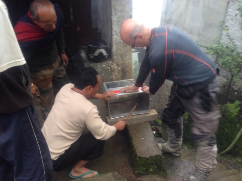 Steve and a local guy working together to fix a damaged Pannier after a crash in mud